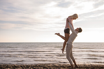 Image showing Loving young couple on a beach at autumn sunny day