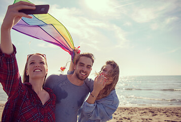 Image showing Group of friends making selfie on beach during autumn day