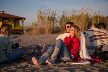 Image showing Couple enjoying with friends at sunset on the beach