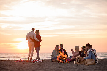 Image showing Couple enjoying with friends at sunset on the beach