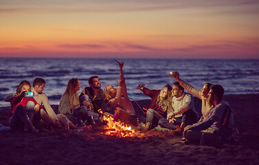 Image showing a group of friends enjoying bonfire on beach