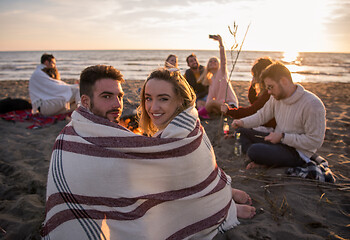 Image showing Couple enjoying with friends at sunset on the beach