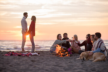 Image showing Couple enjoying with friends at sunset on the beach