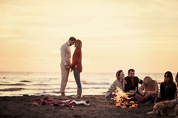 Image showing Couple enjoying with friends at sunset on the beach