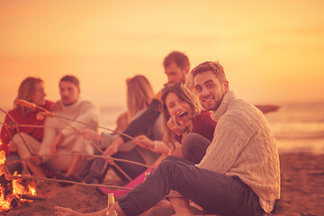 Image showing Group Of Young Friends Sitting By The Fire at beach