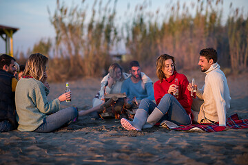 Image showing Couple enjoying with friends at sunset on the beach