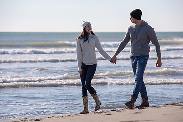 Image showing Loving young couple on a beach at autumn sunny day