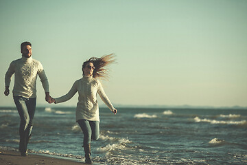 Image showing Loving young couple on a beach at autumn sunny day