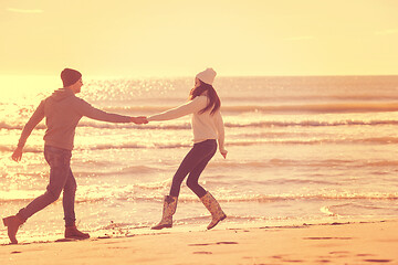 Image showing Loving young couple on a beach at autumn sunny day