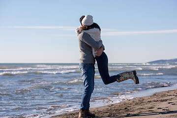 Image showing Loving young couple on a beach at autumn sunny day