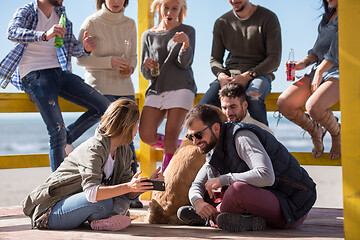 Image showing Group of friends having fun on autumn day at beach