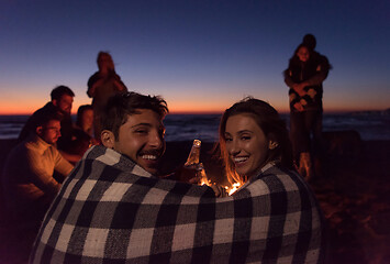 Image showing Couple enjoying with friends at sunset on the beach