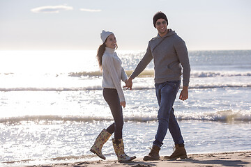 Image showing Loving young couple on a beach at autumn sunny day