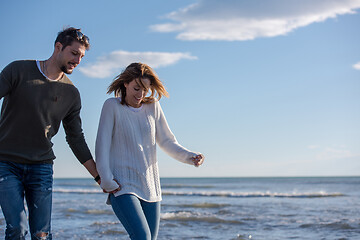 Image showing Loving young couple on a beach at autumn sunny day