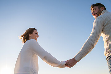 Image showing Loving young couple on a beach at autumn sunny day