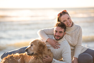 Image showing Couple with dog enjoying time on beach