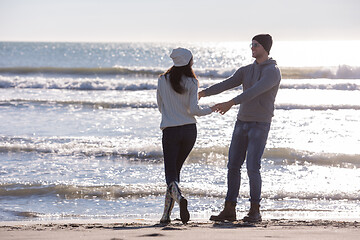 Image showing Loving young couple on a beach at autumn sunny day