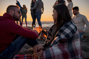 Image showing Couple enjoying with friends at sunset on the beach