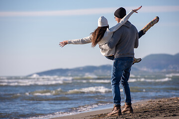 Image showing Loving young couple on a beach at autumn sunny day