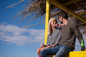 Image showing young couple drinking beer together at the beach