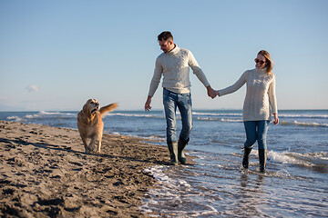 Image showing couple with dog having fun on beach on autmun day