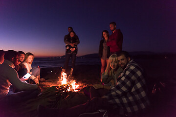 Image showing Couple enjoying with friends at sunset on the beach