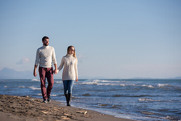 Image showing Loving young couple on a beach at autumn sunny day