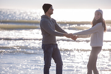 Image showing Loving young couple on a beach at autumn sunny day