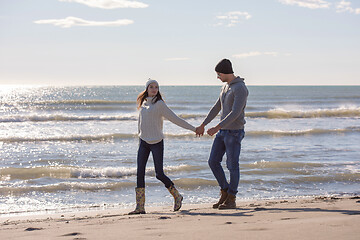 Image showing Loving young couple on a beach at autumn sunny day