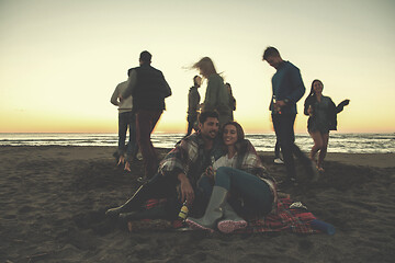 Image showing Couple enjoying with friends at sunset on the beach