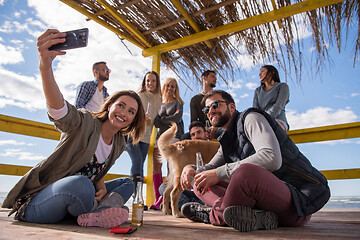 Image showing Group of friends having fun on autumn day at beach