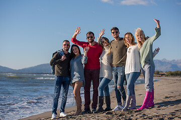 Image showing portrait of friends having fun on beach during autumn day