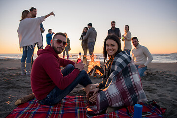 Image showing Couple enjoying with friends at sunset on the beach