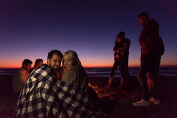 Image showing Couple enjoying with friends at sunset on the beach