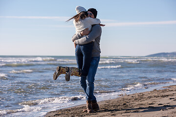 Image showing Loving young couple on a beach at autumn sunny day