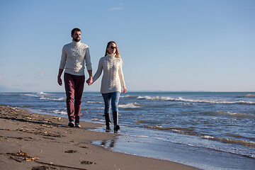 Image showing Loving young couple on a beach at autumn sunny day