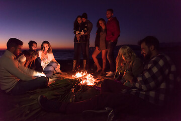 Image showing Couple enjoying with friends at sunset on the beach