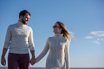 Image showing Loving young couple on a beach at autumn sunny day