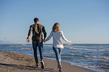 Image showing Loving young couple on a beach at autumn sunny day