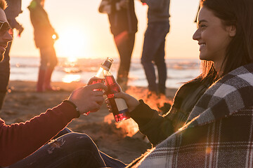 Image showing Couple enjoying with friends at sunset on the beach