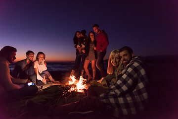 Image showing Couple enjoying with friends at sunset on the beach