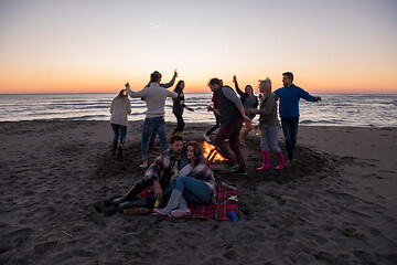 Image showing Couple enjoying with friends at sunset on the beach