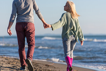 Image showing Loving young couple on a beach at autumn sunny day