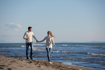 Image showing Loving young couple on a beach at autumn sunny day