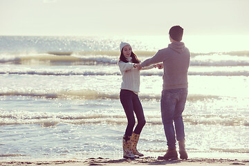 Image showing Loving young couple on a beach at autumn sunny day