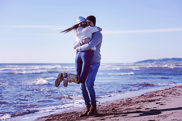 Image showing Loving young couple on a beach at autumn sunny day