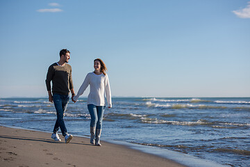 Image showing Loving young couple on a beach at autumn sunny day