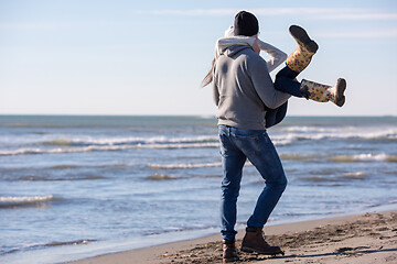 Image showing Loving young couple on a beach at autumn sunny day