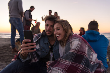 Image showing Couple enjoying bonfire with friends on beach