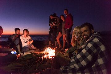 Image showing Couple enjoying with friends at sunset on the beach